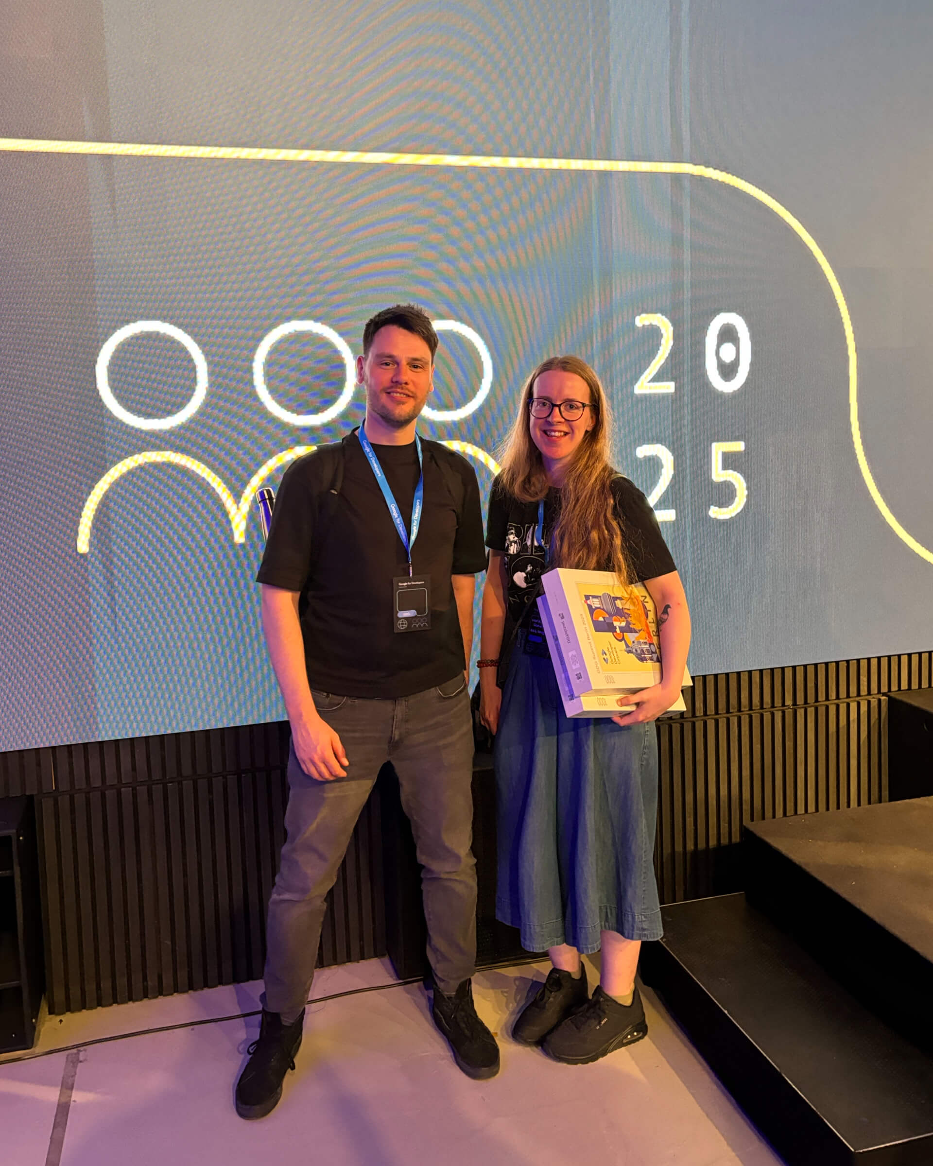 Darren Barklie and Harley Garrett standing in front of a GDG Summit sign that reads '2025'.